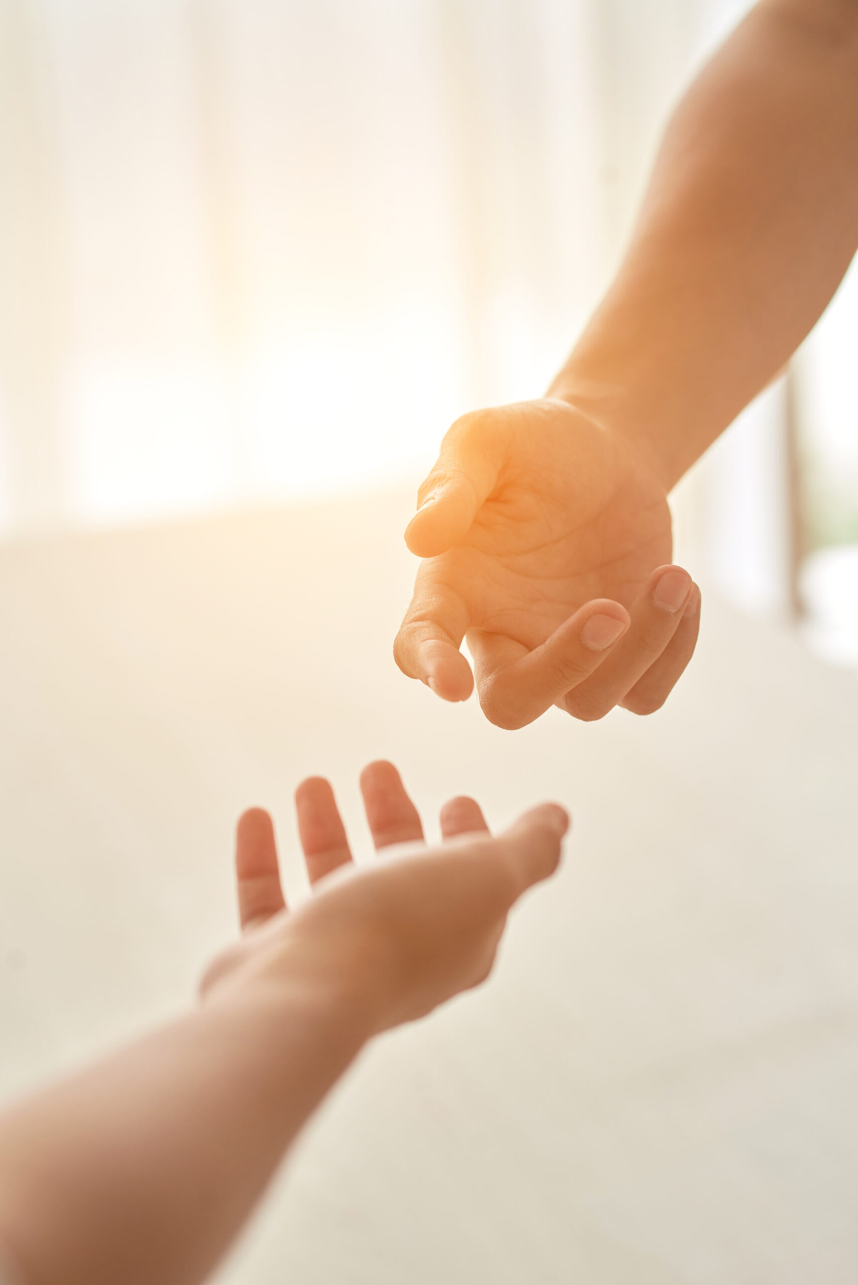 hands couple extended each other against sunlit room scaled