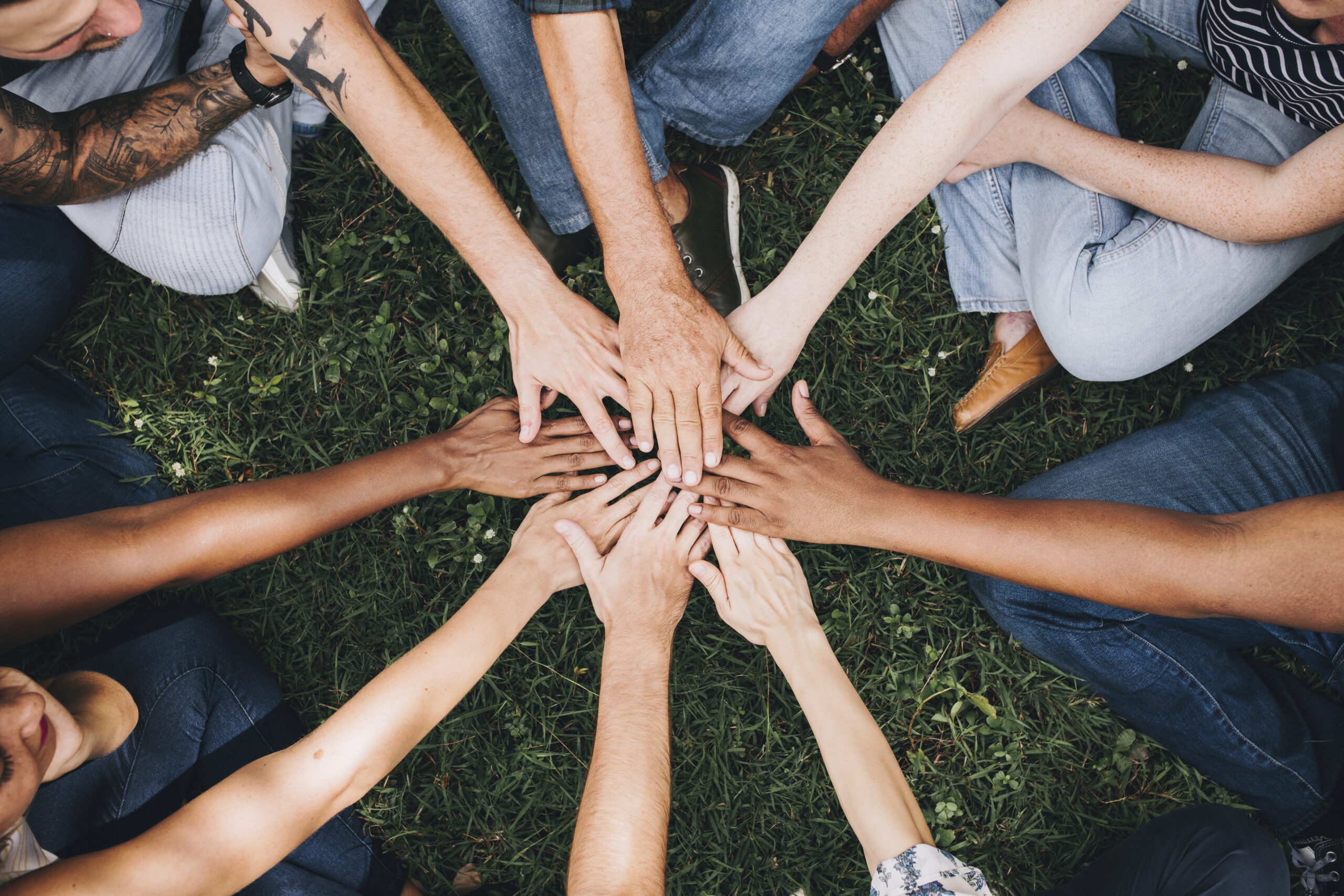 people stacking hands together park scaled